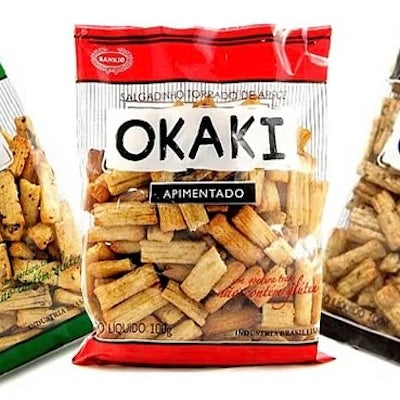 Trois sachets de crackers de riz FISH Okakis aux saveurs assorties, le sachet central portant la mention "Apimentado" en gras et les crackers étant visibles à travers l'emballage transparent.